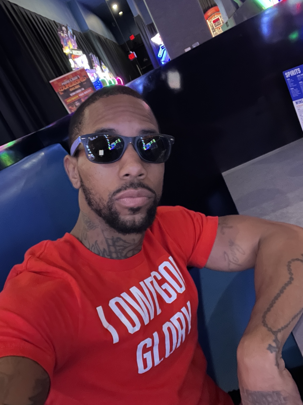 Obedient Apparel model wearing a red Love God Glory tee and sunglasses