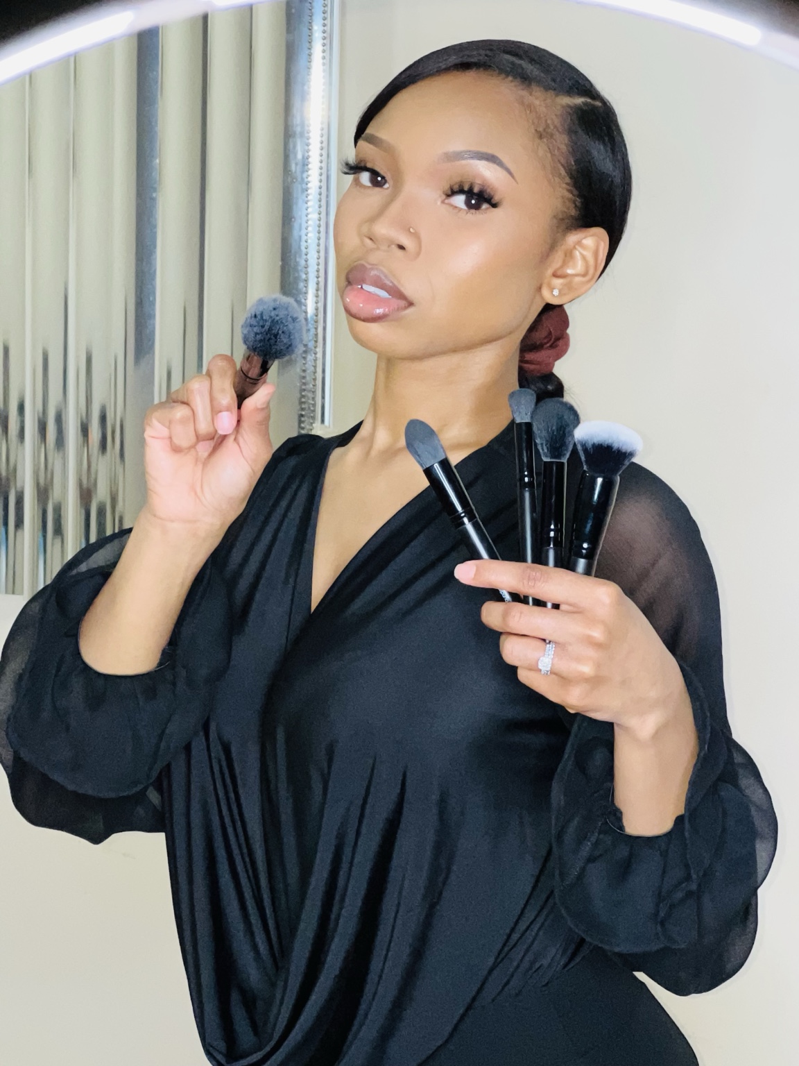 K.S. Artistry Studio model holding makeup brushes